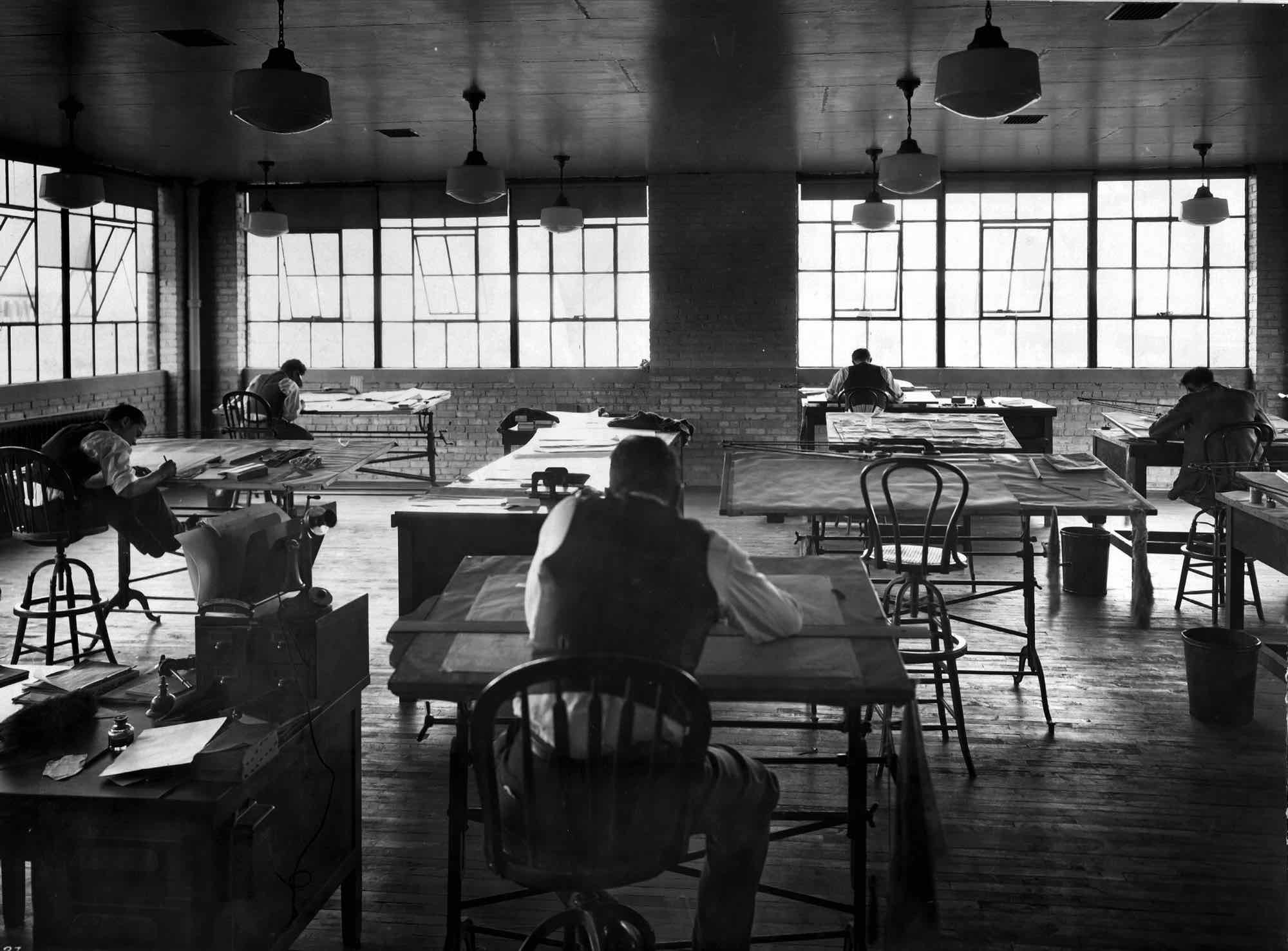 A large drafting room at NACA with high windows and long rows of drafting tables, around 1920.